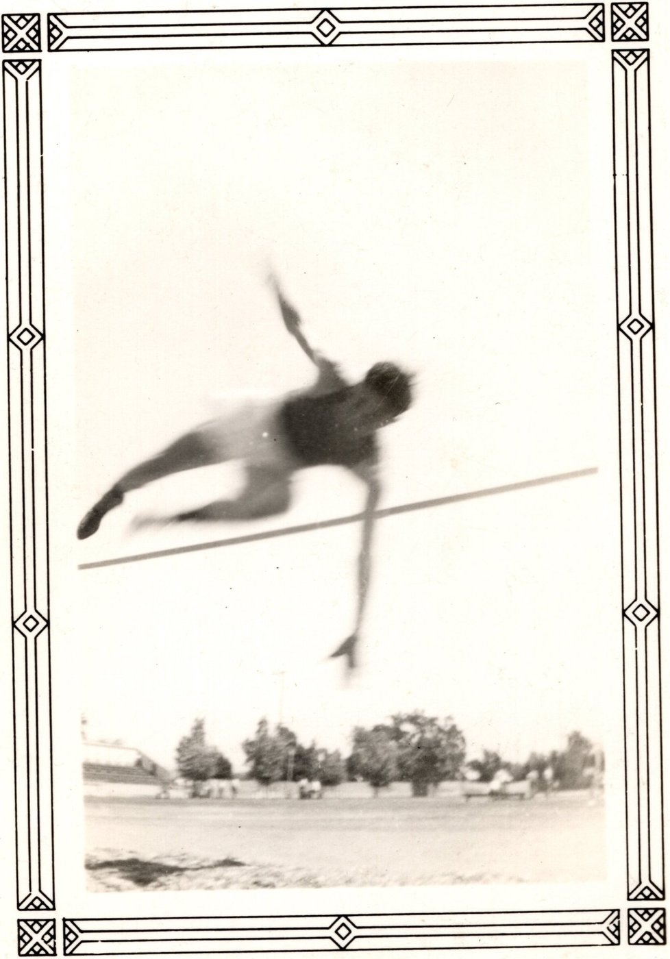 Benny Enea horizontal above the bar, trees and a field behind him