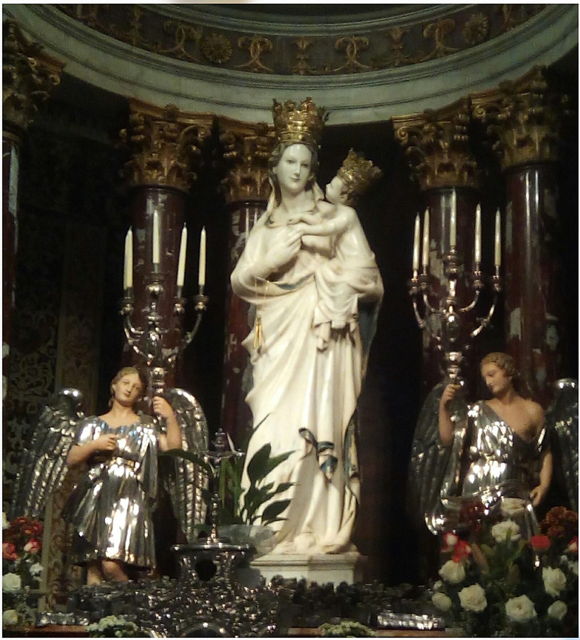 Statue of the Madonna and Child in a richly decorated Sicilian church setting