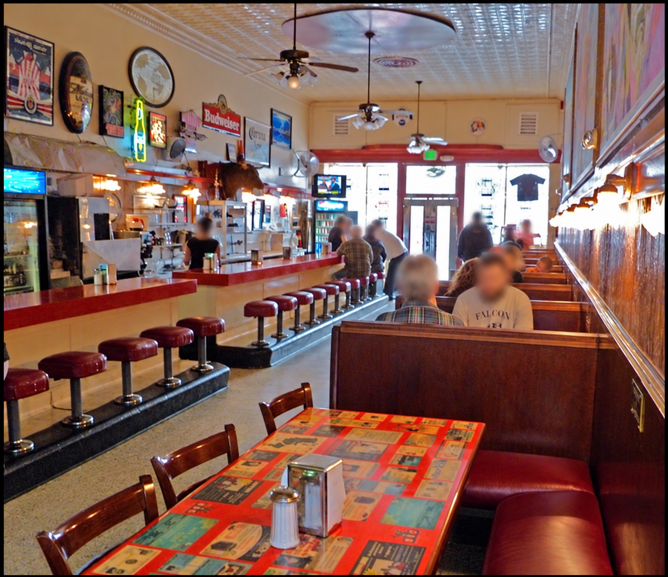 Interior of The New Mecca Cafe with a long counter, red stools and wooden booths