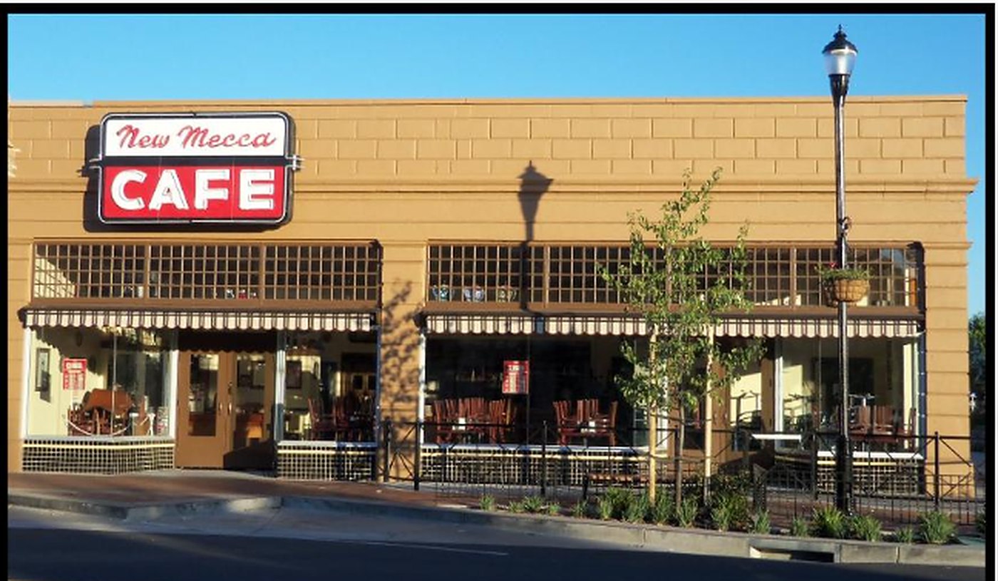 The exterior of the New Mecca Cafe in Pittsburg, California, its red neon sign above the awnings