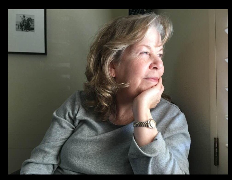 Barbara Stubbs gazing out of a window, chin resting on her hand