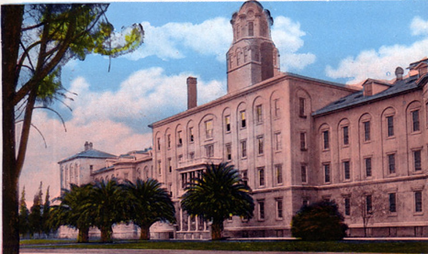 A historical view of the Stockton State Hospital buildings behind palms and lawns