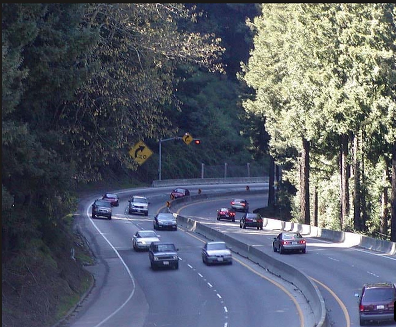 Highway 17 curving through redwood-covered hills, traffic in both directions