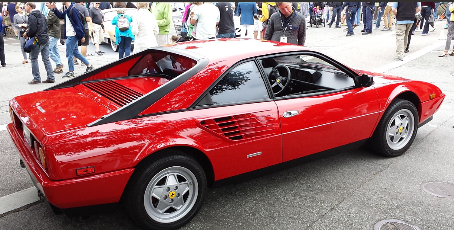 A red 1987 Ferrari Mondial Coupe seen from the rear three-quarter at a car show