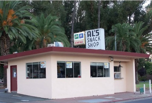 A small single-storey snack shop with a red roofline and a rooftop sign reading Al's Snack Shop