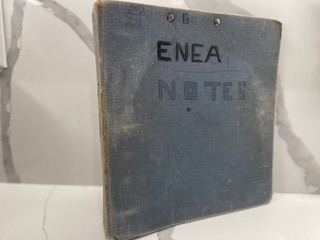 A worn grey school binder with ENEA and NOTES lettered on the cover