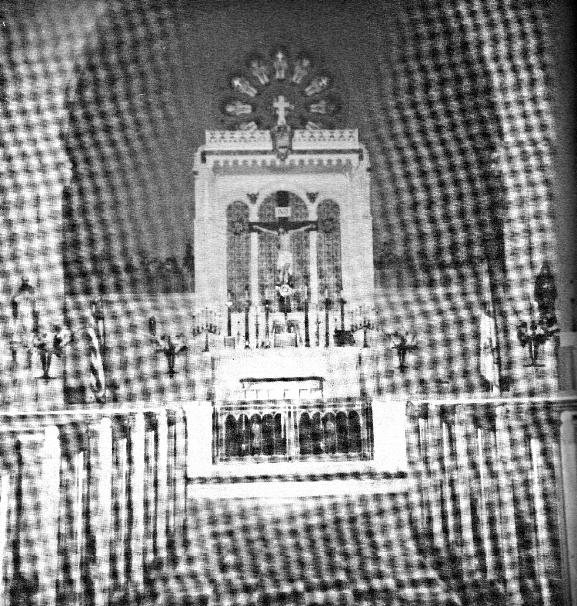 The interior of a church looking down the aisle toward the high altar and crucifix