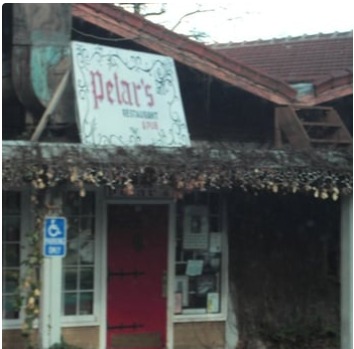 The front entrance of Petar's Restaurant beneath a hanging sign, with a red door and a string of lights along the eaves