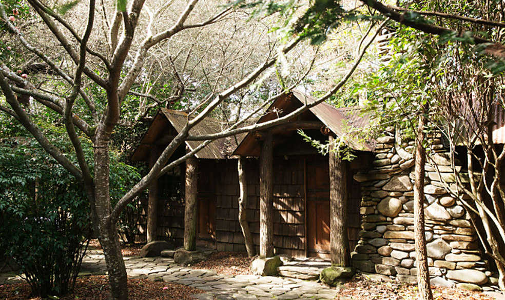 Shingled wooden cabins among trees at Manka's in Inverness