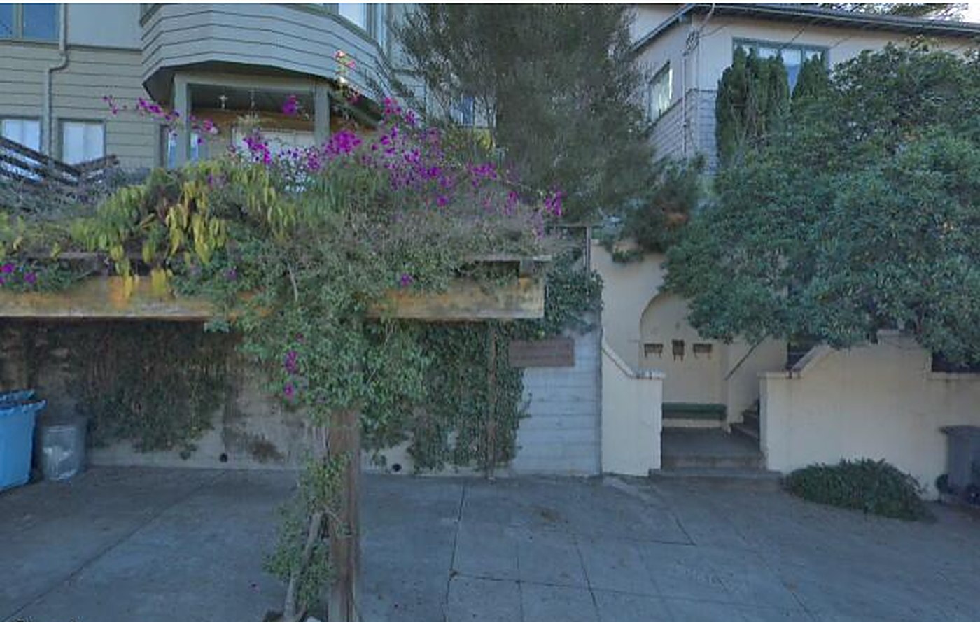 A shared forecourt with a bougainvillea-covered pergola and steps rising between retaining walls