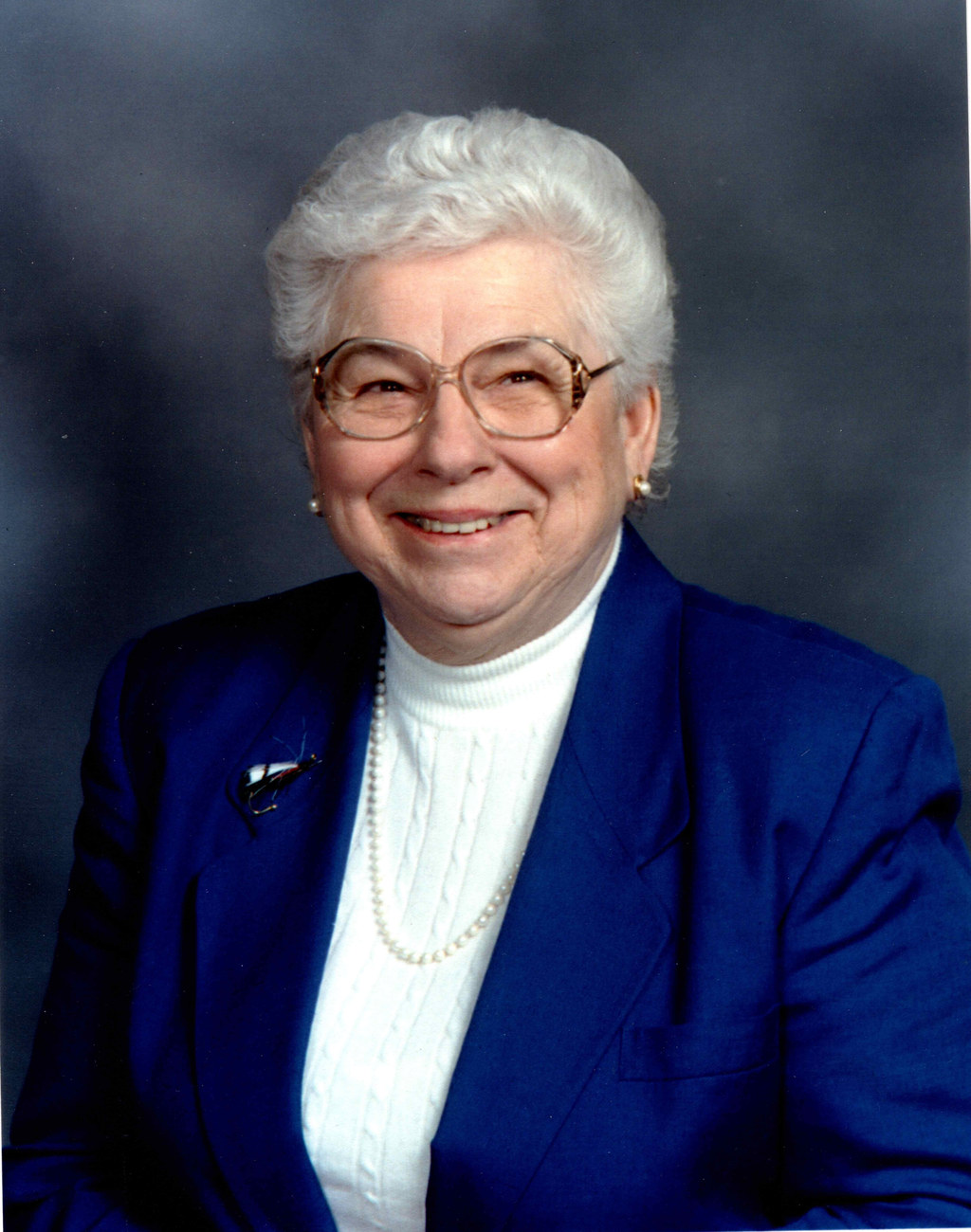 Studio portrait of Nadine Montgomery in a blue jacket and pearls, 2002