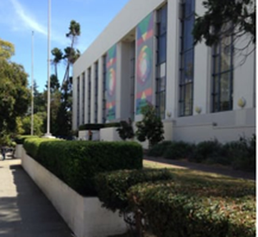 The exterior of the Oakland Main Library, banners hung along its facade